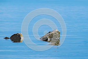 Stones on the water, sea, calm sea with clear cold blue water