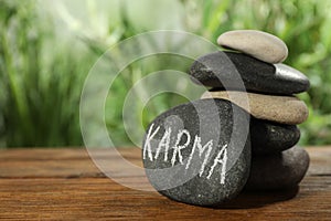 Stones with word Karma on wooden table, closeup. Space for text