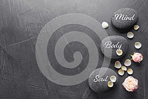 Stones with words MIND, BODY, SOUL on grey background, top view with space for text