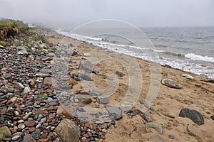Stoney Beach in front of a mist covered sea. Scotland, UK.