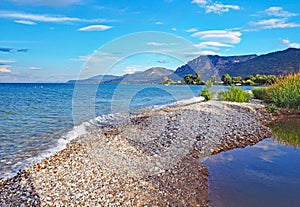 The stoney shores of Nikolaiika Beach on the Corinthian Gulf in Greece