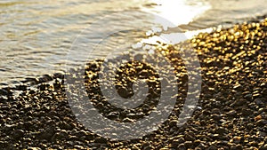 Stony beach close up at sunsetsunrise, pebble on the  sunsetsunrise beach, sea wave and pebble shore close-up