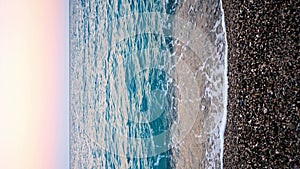 Stony beach and sea waves at sunset light in evening time, Turkey