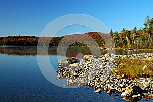 Stony beach and sunrise over beautiful lake