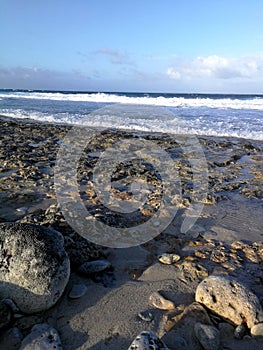 Stony beach at sunset light and blue sky