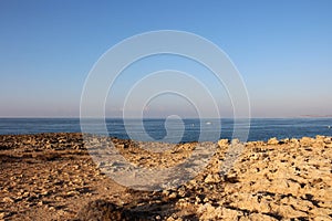 A stony, lifeless beach against the sea and blue sky. Ayia Napa. Cyprus