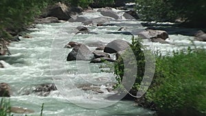 The stony mountain river rages and jumps through stones