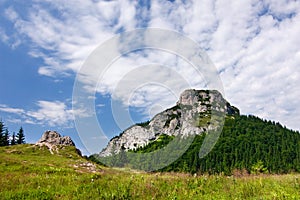 Stony peak and blue sky with clouds