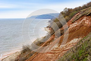 Stony, pebble and clay banks of the Volga River. Mountain slope of various stone rocks. Spring cloudy day with rain. Beautiful