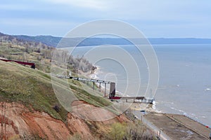 Stony, pebble and clay banks of the Volga River. Mountain slope of various stone rocks. Spring cloudy day with rain. Beautiful