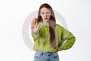 Stop. Angry ginger girl stretch hand to prohibit, reject and disapprove, decline something, say no, forbid action photo