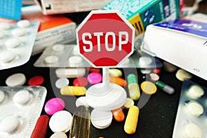 Stop antibiotics or medication excess with colorful pharmaceutical drugs with stop sign on top