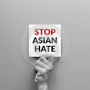 Stop Asian hate concept. hand holding card paper sheet with word stop Asian hate for poster of campaign