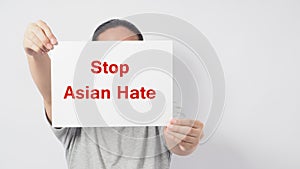 Stop asian hate in red color write in white board paper.Asian man holding paper on white background photo