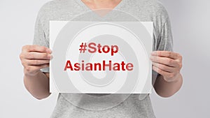 Stop asian hate in red color write in white board paper.Asian man holding paper on white background photo