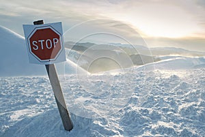 Stop. Avalanche sign in front of winter snowy mountains. r