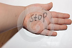 Stop at the babyâ€™s hand. Stop it is written on the childâ€™s hand. Stop abuse.