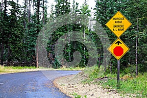 A Stop and Barricade Ahead sign along a road