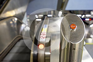 STOP button for immobilizing escalators.  Button on the right side.  Stairs blurred on the left side.