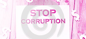 Stop Corruption Words on page and paper dollar signs around on wooden table. Anticorruption business concept photo