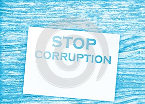 Stop Corruption Words on page and paper dollar signs around on wooden table. Anticorruption business concept photo