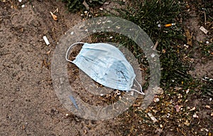 Stop Covid 19. The end of coronavirus. People discard surgical protective face mask on a public streets. Dirty used medical mask