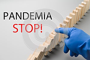 Stop COVID-19. A hand in a blue medical glove stops the domino effect. Preventive measures to combat the global spread
