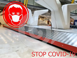 Stop COVID-19. Warning medical protection mask sign on baggage claim at Europeane airports background