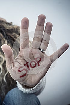 Stop crime violence abuse on women from men - woman protect herself sitting on the ground with hand to defense - home crime