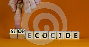 Stop ecocide symbol. Businessman turns wooden cubes and changes words ecocide to stop ecocide. Beautiful orange background, copy