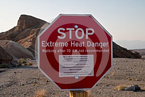 Stop! Extreme heat danger landmark red sign in the hot ridges of Zabriskie Point, Death Valley National Park, California, USA