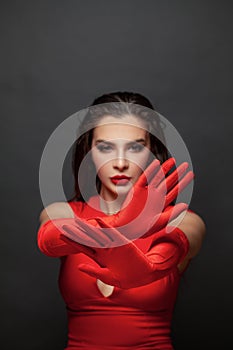 Stop gesture. Brunette woman hands in red silky gloves showing stop gesture, negation, denial and no