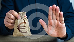 Stop gesture and euro money bag. Financial difficulties. Economic sanctions, confiscation of funds. The man does not approve of