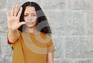 Stop, hand and portrait of woman for warning, rejection or sign against wall. Serious, gesture and face of gen z female