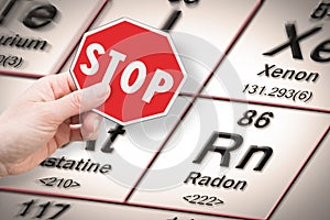 Stop heavy metals - Concept image with hand holding a stop sign against a radon chemical element with the Mendeleev periodic table