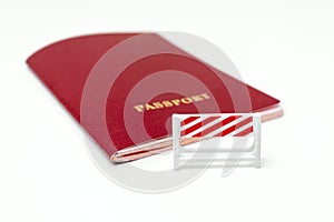 Stop illegal migration concept, red biometric international passport with a road barrier on white background