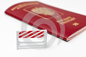 Stop illegal migration concept, Russian biometric international passport with a road barrier on white background