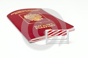 Stop illegal migration concept, Russian biometric international passport with a road barrier on white background