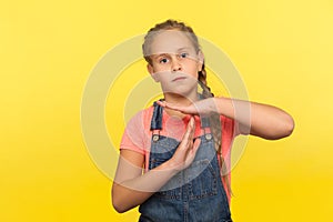 Stop, limit gesture. Portrait of tired unhappy little girl with braid in denim overalls showing timeout, child asking break