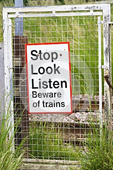 Stop look listen safety road sign at railway train station danger warning sign