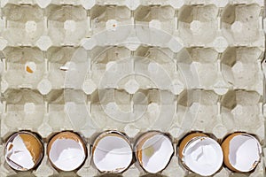 Stop motion flat lay of a box with broken eggshell brown chicken eggs, background texture pattern