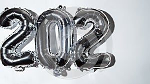 Stop motion Happy new year 2023 metallic balloons on white background. Greeting card silver foil balloons numbers