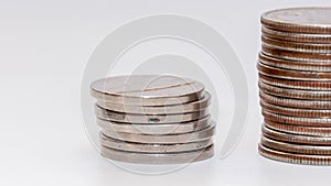 Stop motion reduces a stack of coins on a white background, camera movement. Concept: falling incomes, financial crisis.