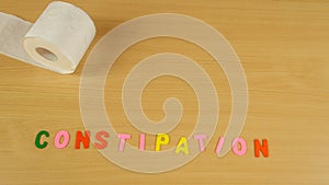 Stop motion time lapse of toilet paper rolling constipation symbol with alphabet letters moving with a pillbox