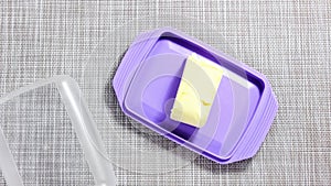 Stop motion video. The cut butter is transferred to the lilac butter dish.