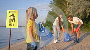 Stop plastic, portrait of happy volunteer child girl in rubber gloves with trash bag near pointer sign on background of