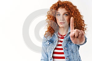 Stop please. Timid serious-looking redhead cute girl gather courage extend index finger taboo prohibition gesture