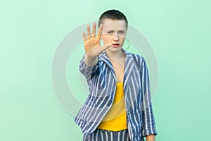 Stop. Portrait of serious handsome beautiful short hair young stylish woman in casual striped suit standing blocking and showing