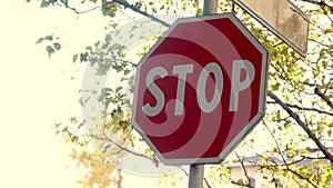 Stop road sign. On the background, an autumn landscape of a small town.