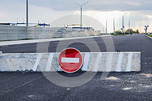 A stop road sign and concrete blocks block the entrance to the construction site. Closed road. Construction and road works